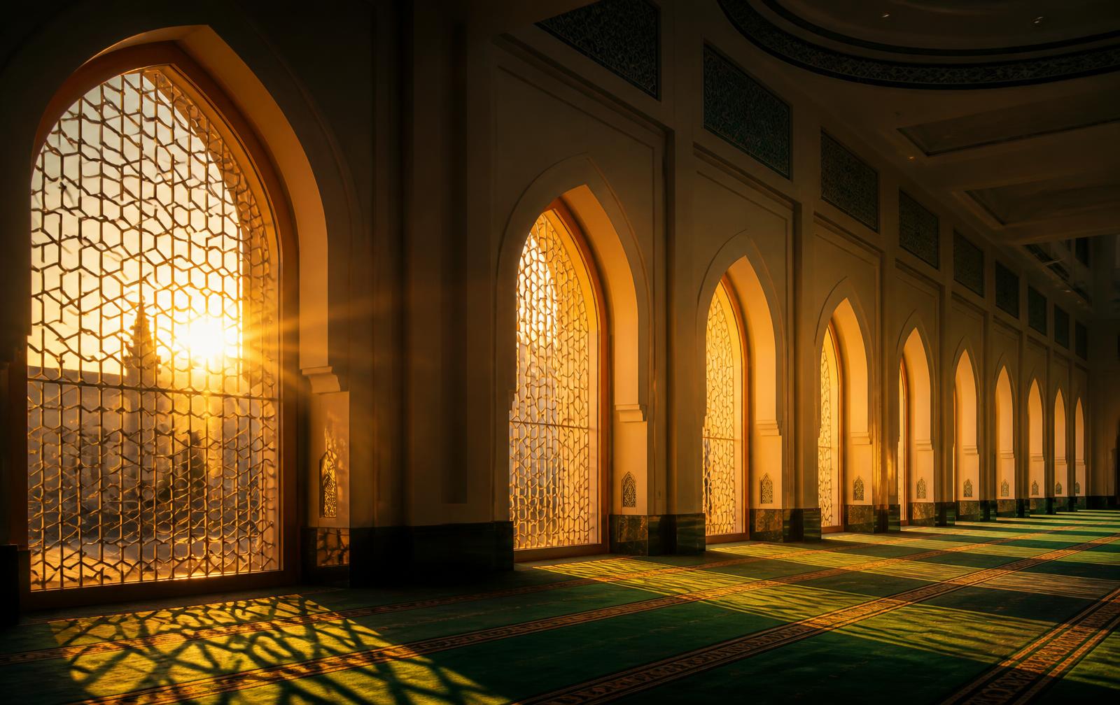 Sunlight streaming through the arches of a mosque prayer hall